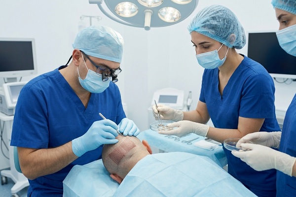 Two nurses assisting the hair transplant specialist during the procedure
