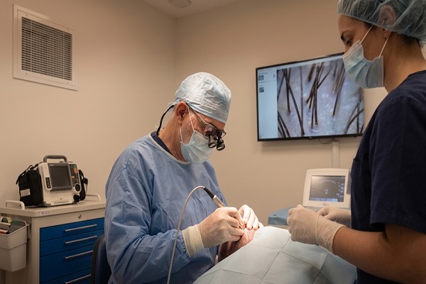 Doctor realiza un trasplante capilar en un quirofano que cumple con los requisitos legales para clínicas capilares